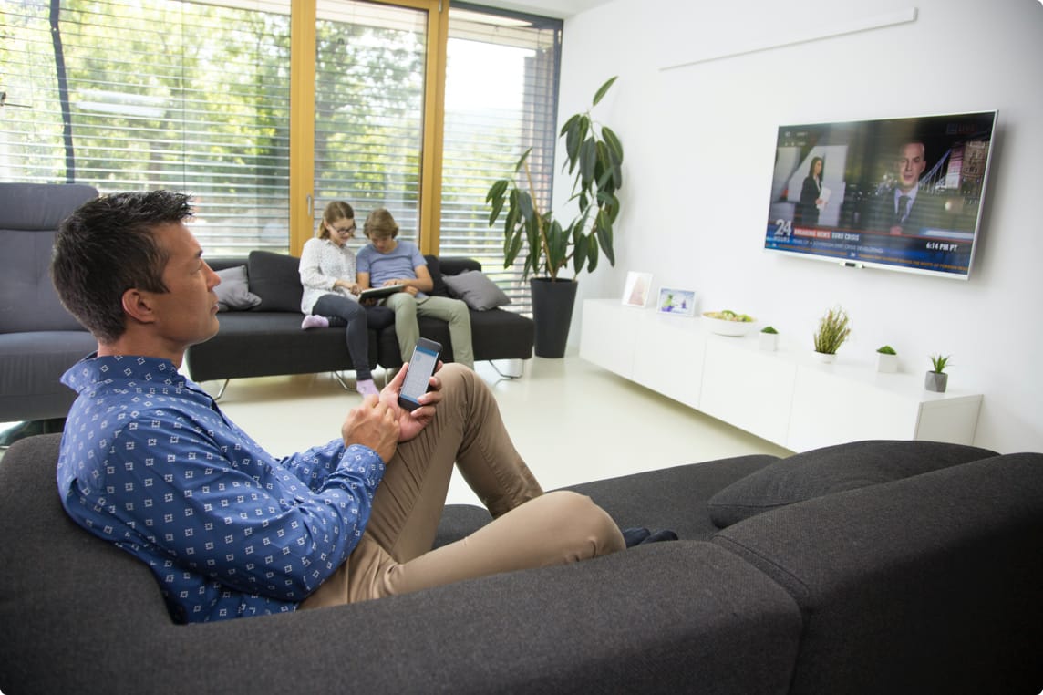 Family sittuing on couch with devices
