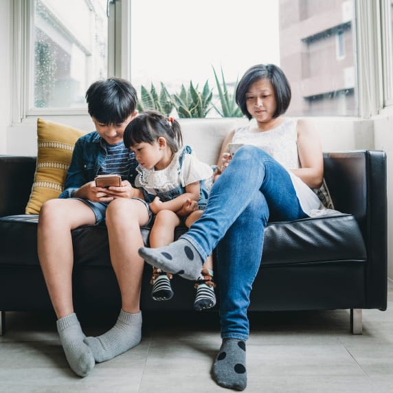 family on couch with devices