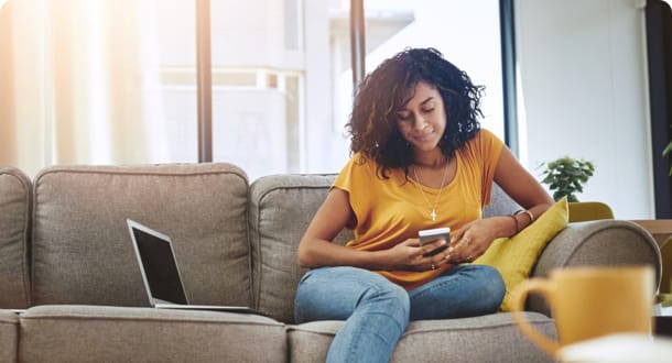 woman checking phone on couch
