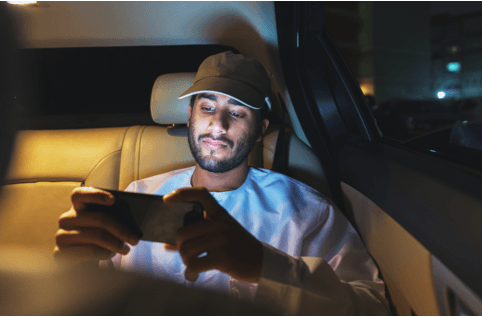 Man watching something on phone while riding in an Uber car